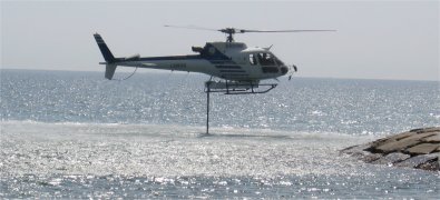 Elicottero in volo stazionario carica l' acqua dal mare